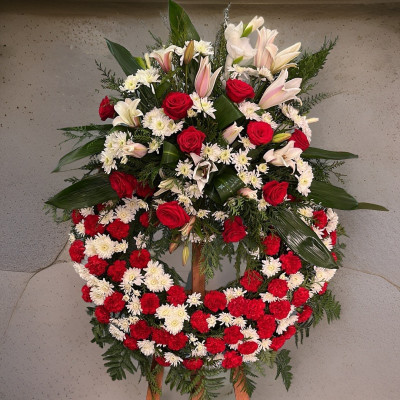 Corona de flores naturales elaborada con claveles rojos, blancos y flor variada
